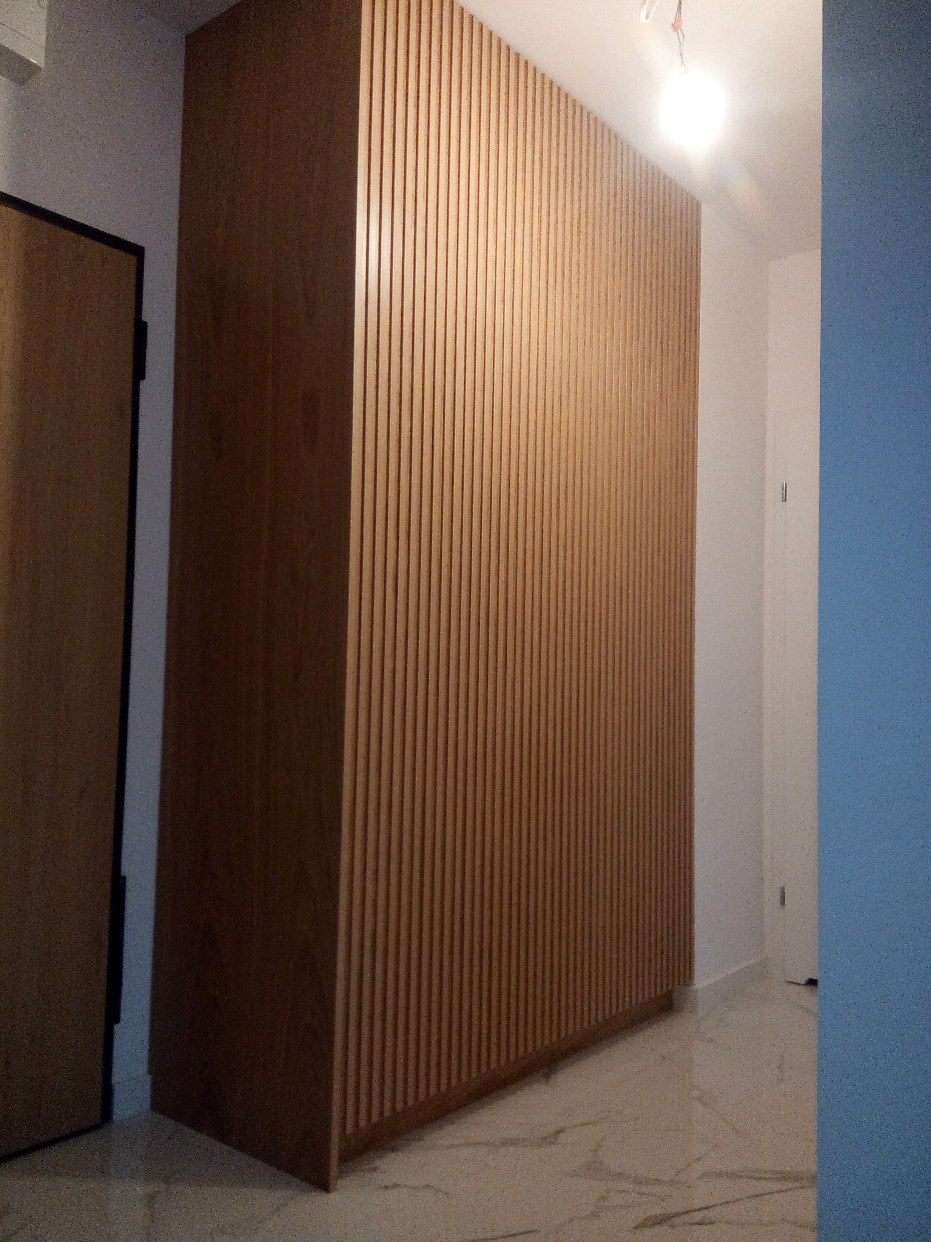 Zabudowa ściany z pionowymi lamelami drewnianymi