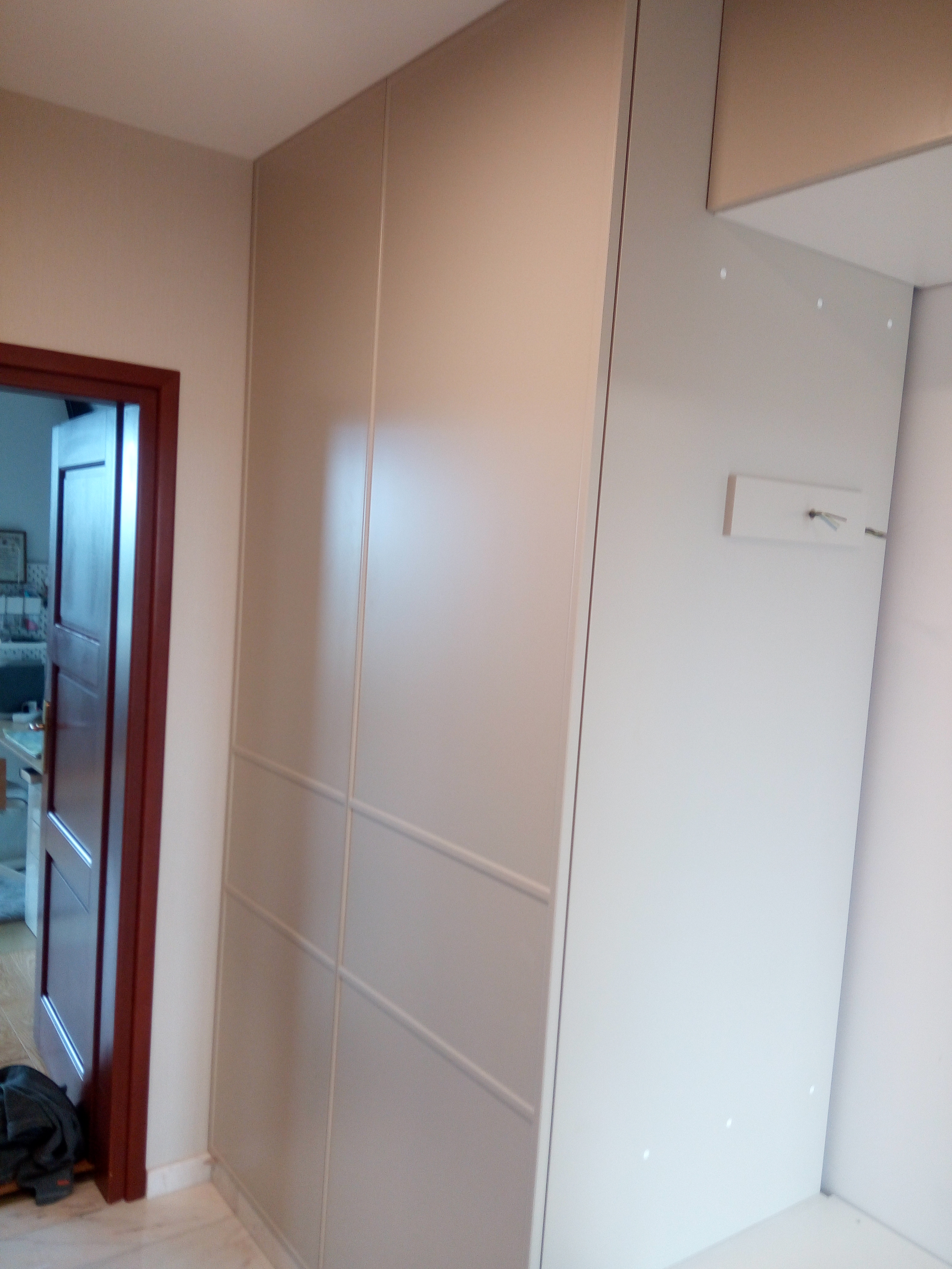 Wysoka beżowa szafa w przedpokoju