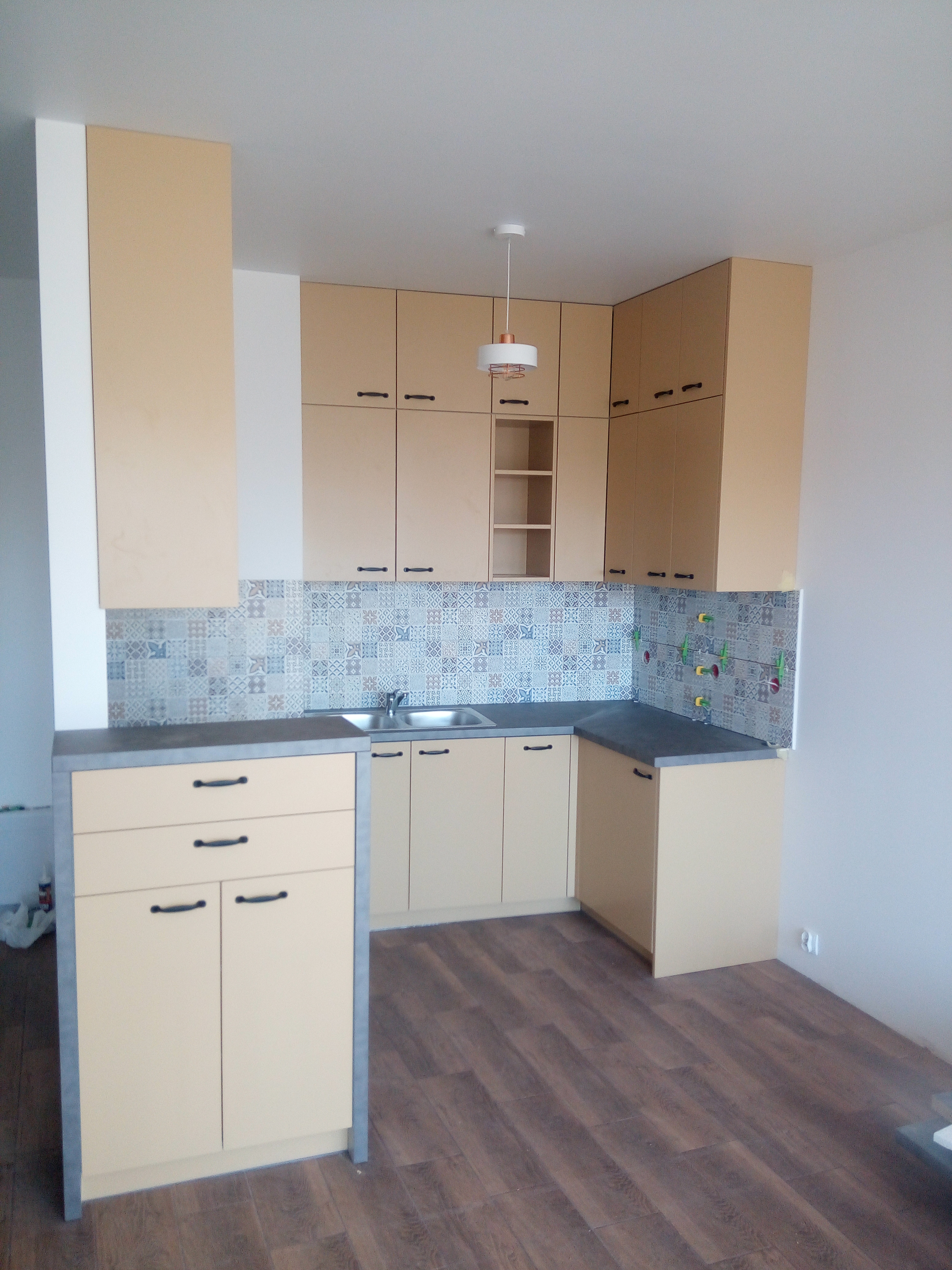 Kuchnia w ciepłym kolorze z dekoracyjną płytką